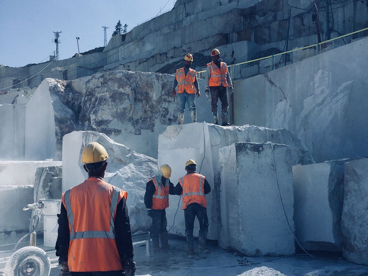 Quarry team inspecting marble blocks for quality